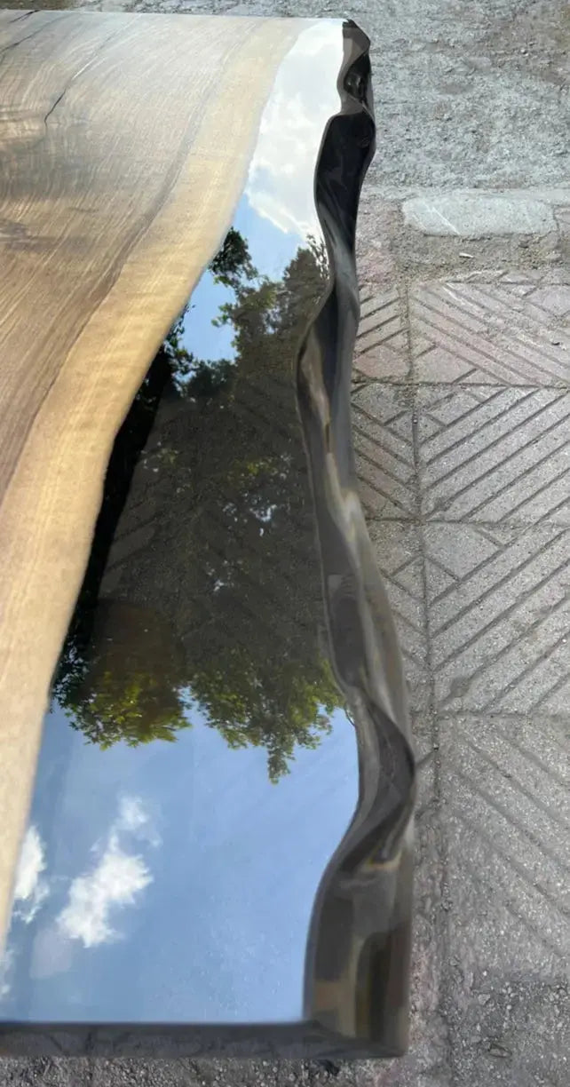 Wooden bench with a reflective surface on a textured pavement