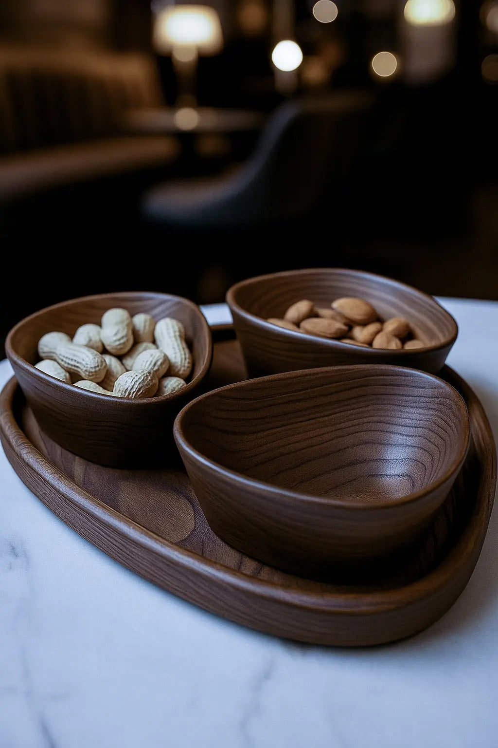 Wooden bowls with snacks on a marble surface