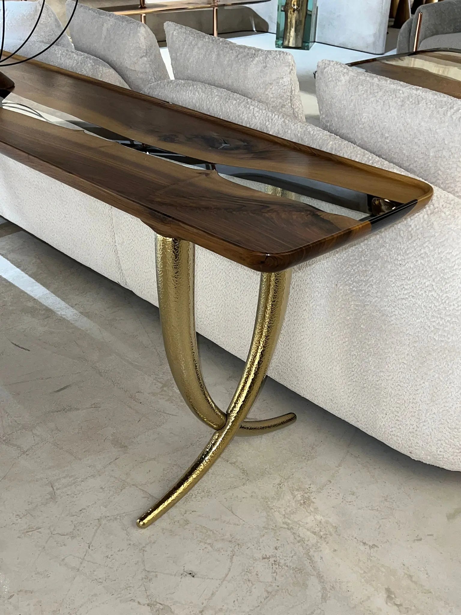 clear resin sofa table featured golden legsin front of a sofa