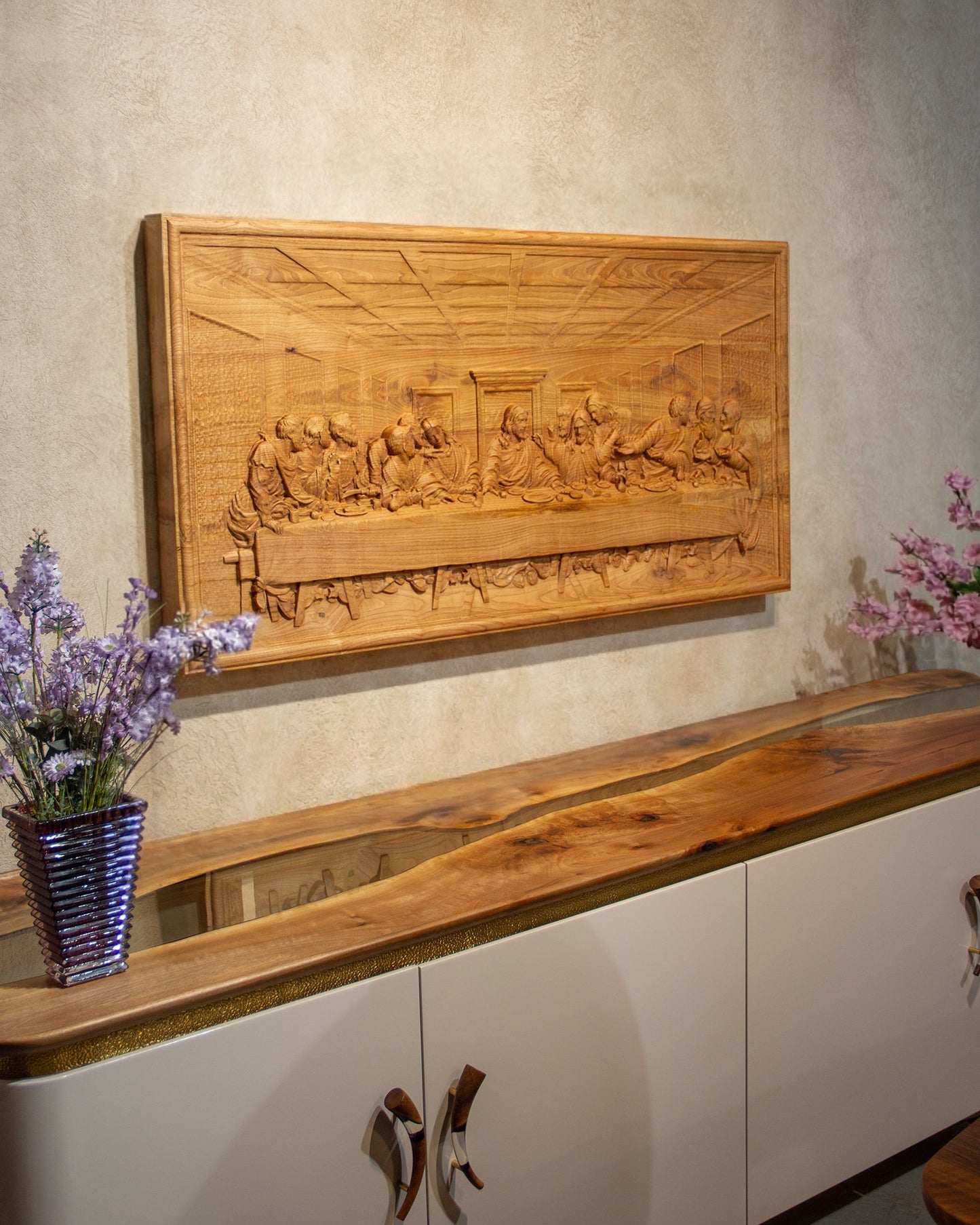 Wooden wall art above a white cabinet with wooden top