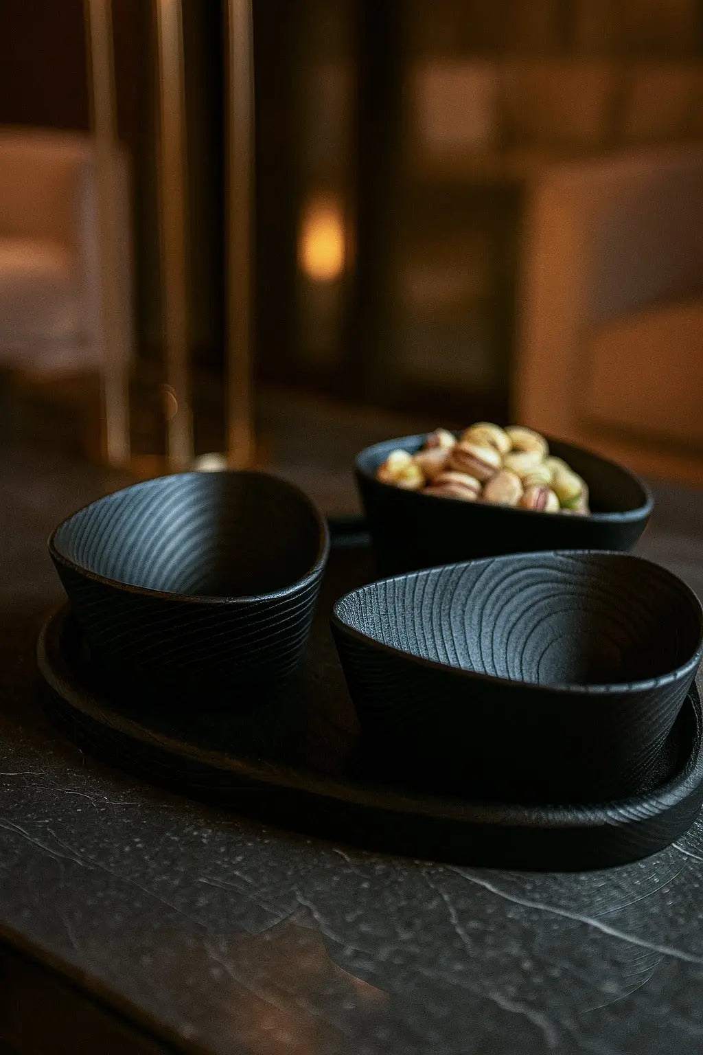 Set of black ceramic bowls on a tray with a blurred background