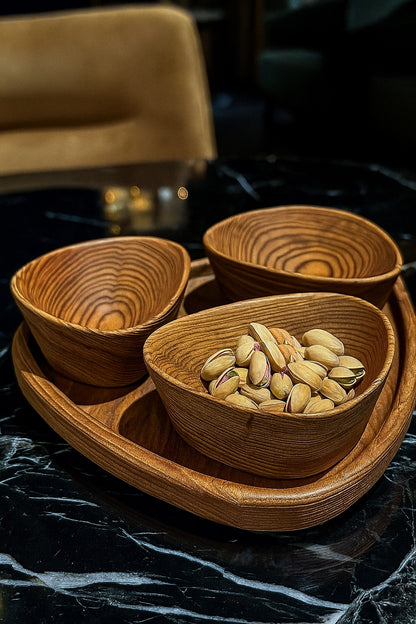 Wooden bowls with pistachios on a dark surface