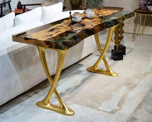 Elegant coffee table with gold legs and a wooden surface in a living room setting.
